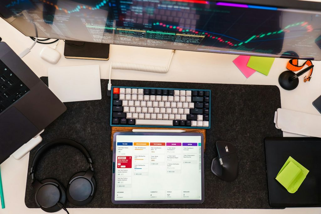 Monitör, klavye ve tablet bulunan düzenli bir çalışma masası